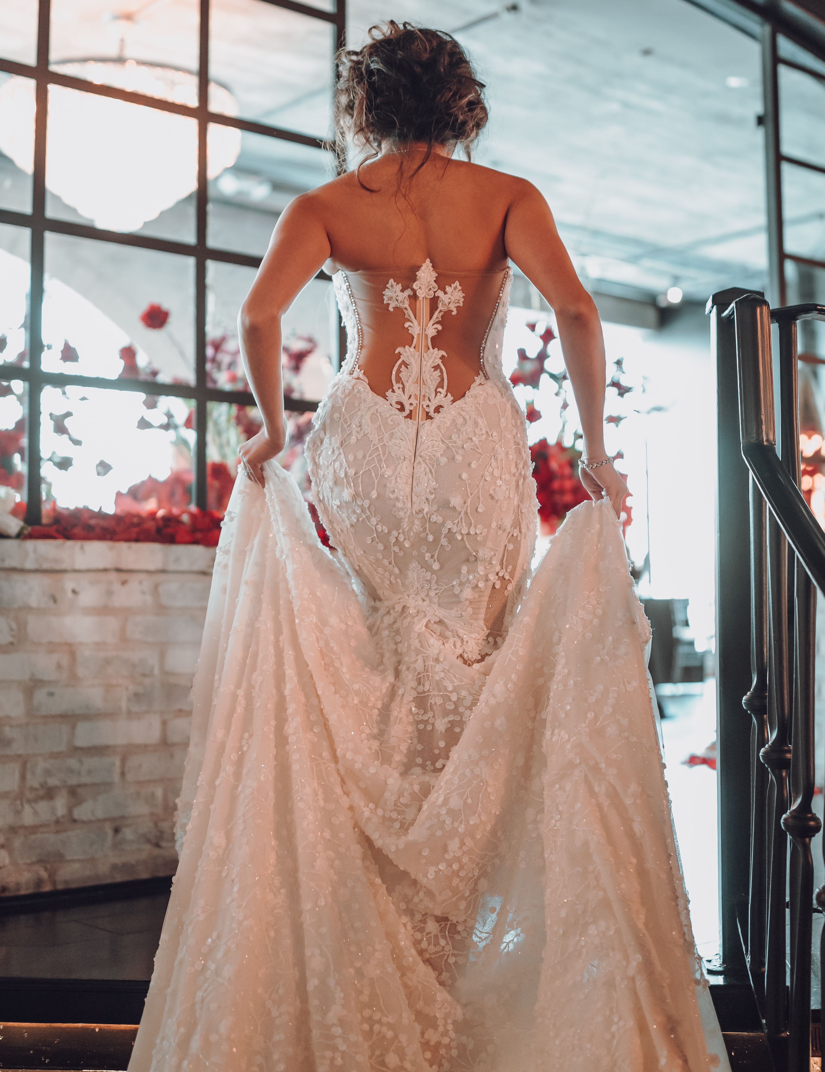 A bride wearing a Galia Lahav gown walks up a small flight of stairs on her wedding day at The Astorian in Houston, Texas. 