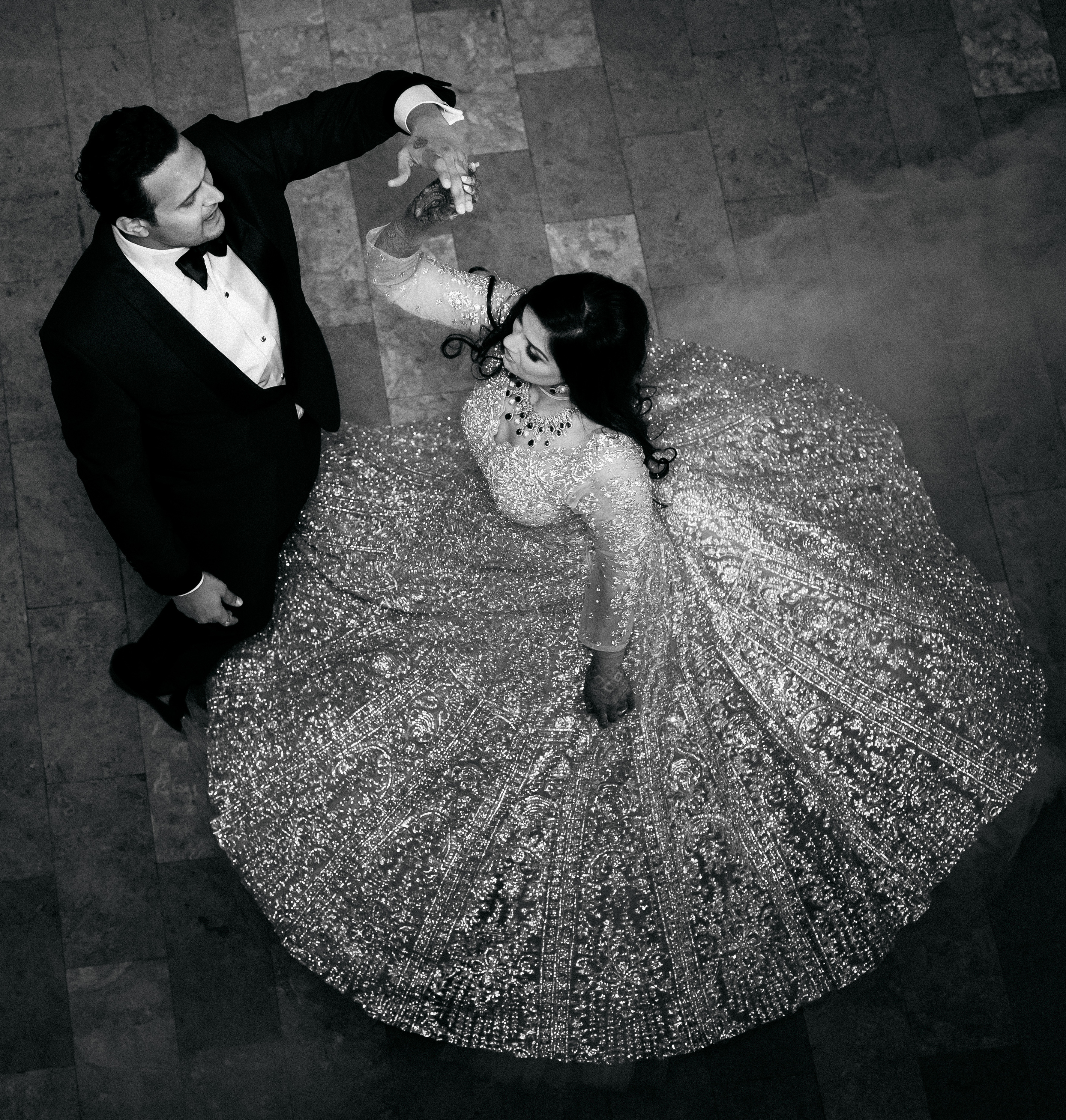 A black and white photo of the bride and groom dancing at their wedding reception. 
