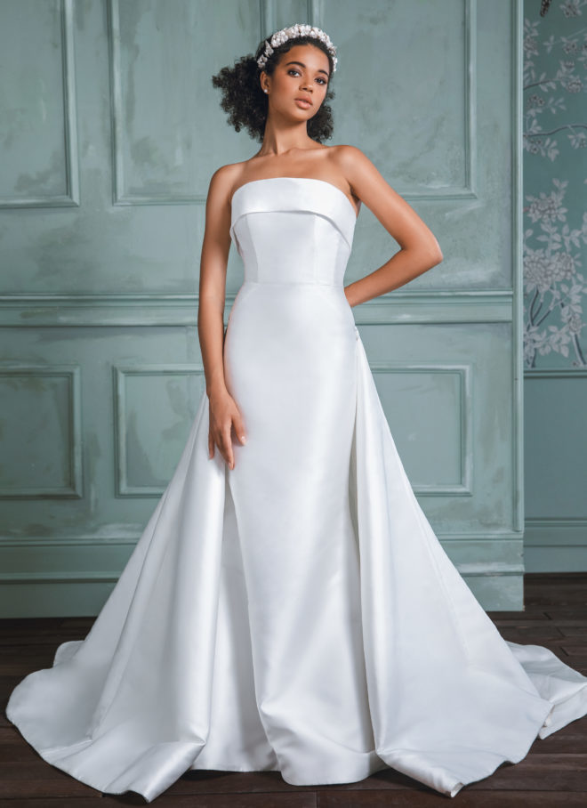 Model in strapless trumpet wedding dress with classic cuff by Anne Barge. 