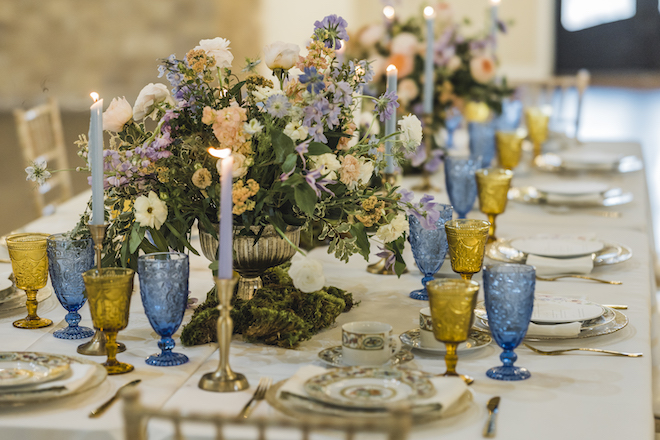 Detailed fine china and pastel flowers decorate the table at the wedding reception at the venue, The Hundred Oaks