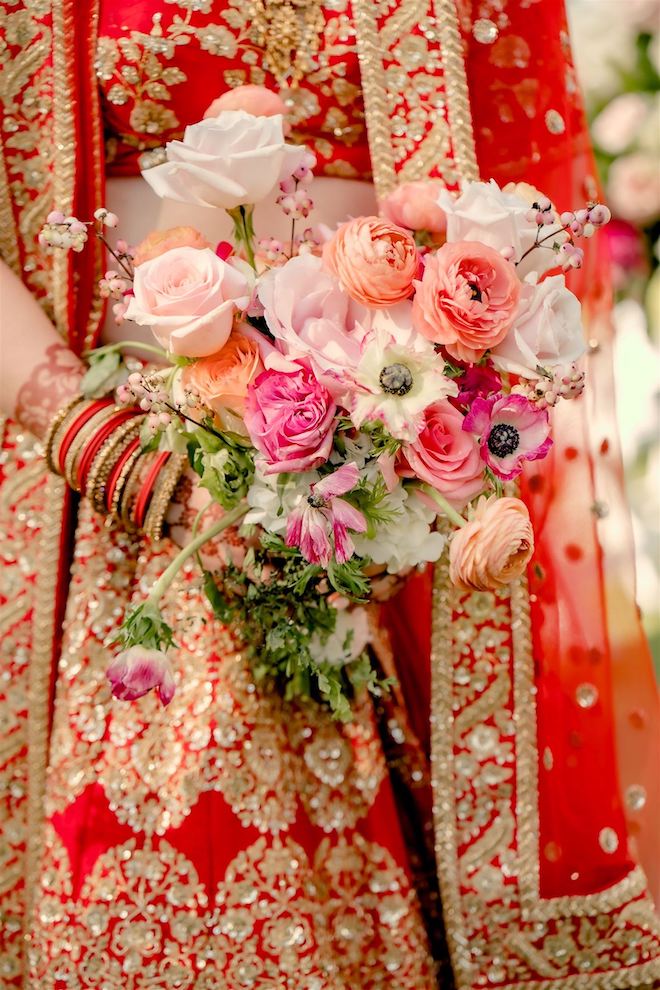 Bride holding her bouquet filled with pink, cream and peach florals