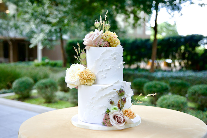 White wedding cake with florals decorating it for the modern minimalistic wedding editorial.