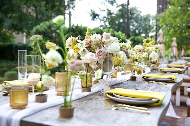 Close-up of the tablescape with yellow napkins and gold silverware.