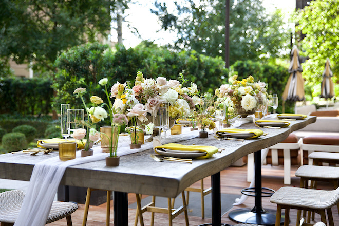 Tablescape decorated with bouquets of yellow, white and blush flowers.