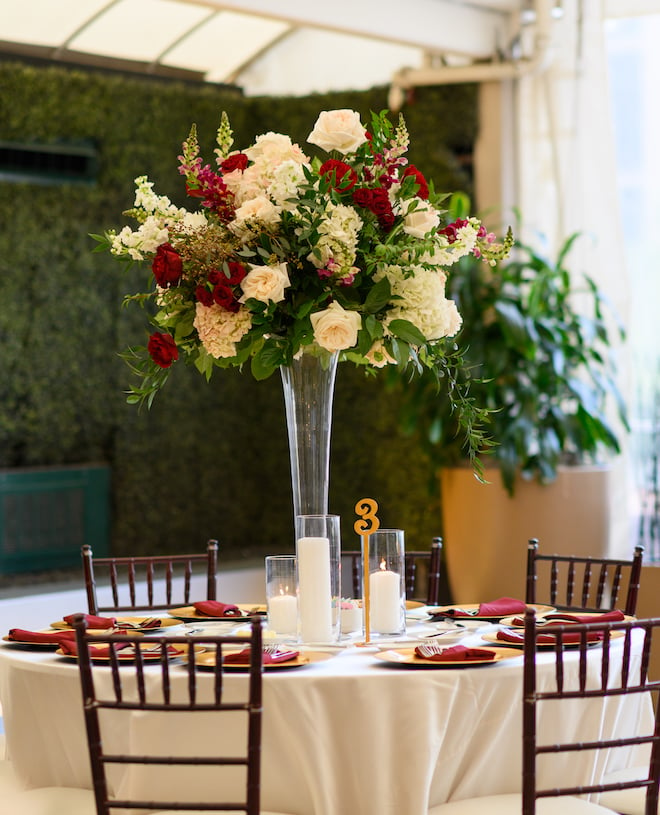 Red, blush and white roses decorate the tables at the timeless wedding reception. 