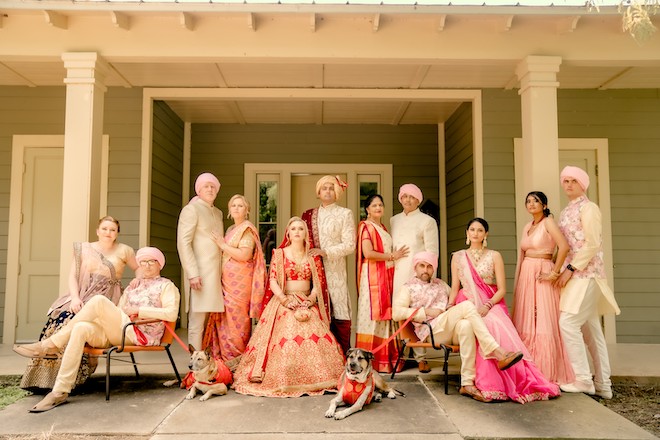 Both families of the bride and groom posing in traditional Indian attire.