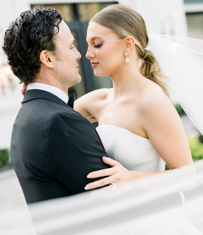 The bride and groom look into each others eyes outside their wedding venue, The Peach Orchard.