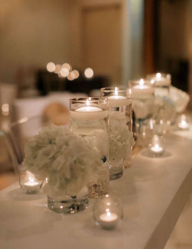 Small floral centerpieces and lit tea lights on a table in the ballroom of Bell Tower on 34th. 