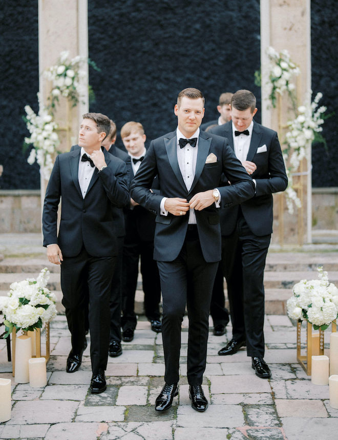 Groom and groomsmen walking down aisle in courtyard of wedding venue, The Bell Tower on 34th. 