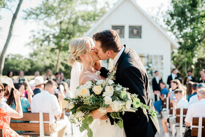 The bride and groom kiss outside as they leave their ceremony at 7F Lodge and Events. 