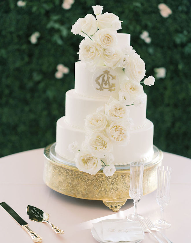 Four tiered wedding cake garnished with ivory roses by Susie's cakes. 