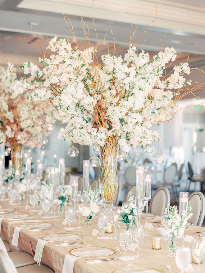 The cherry blossom centerpiece over the gorgeous blush and ivory tablescape.