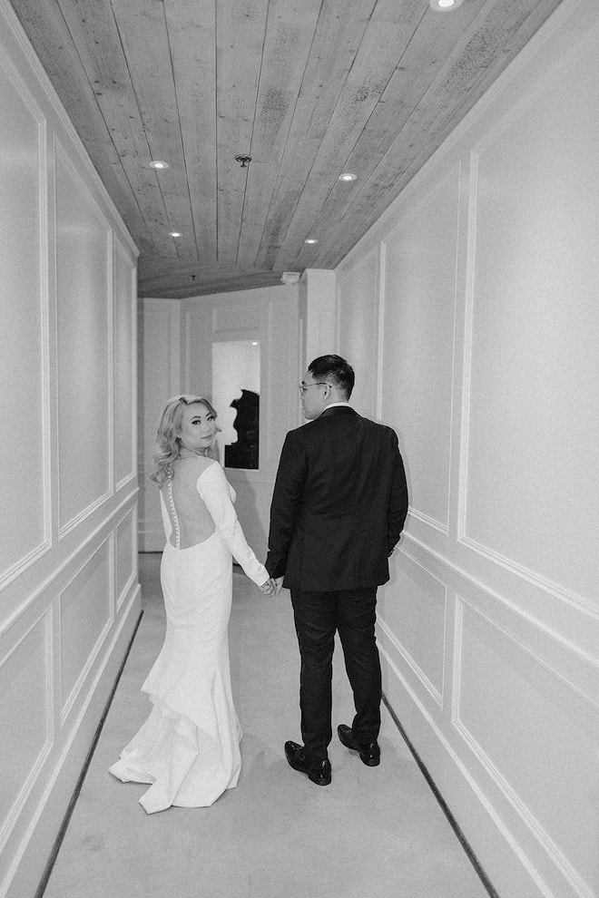 bride walks hand in hand with groom in the hallway leading to the Astorian's bridal suite, Soho Suite. 