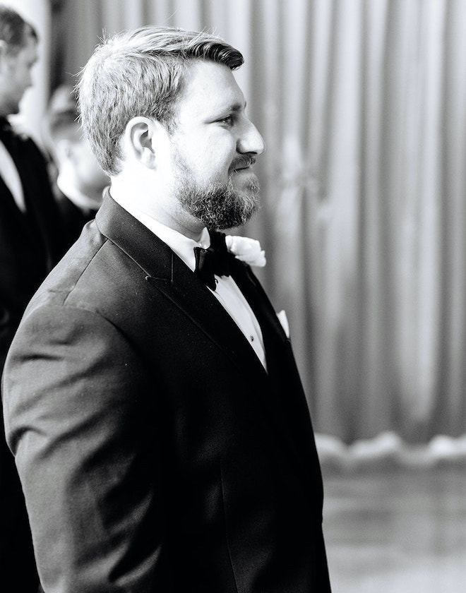 The groom tearing up as he watches the bride walk down the aisle.