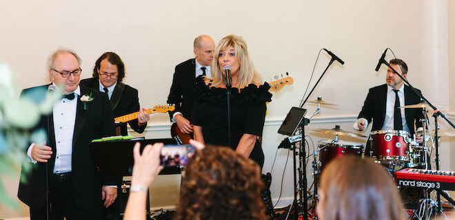 The bride's mother singing her favorite song with the band "The Moment" for the couple's first dance.