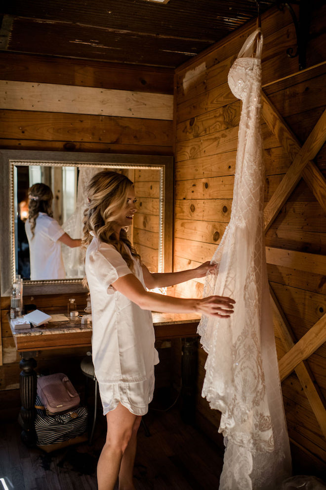 The bride looking at her dress hung up before putting it on