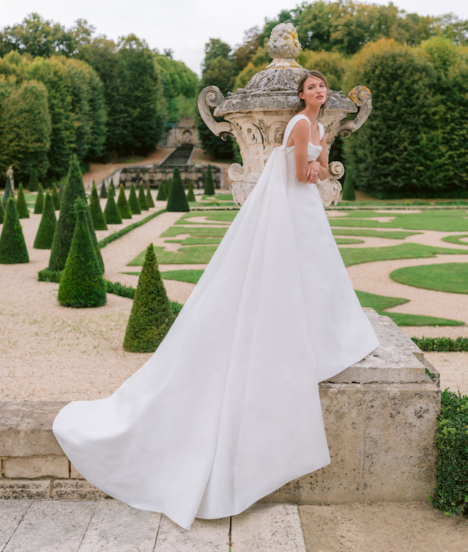Model wearing a Monique Lhuillier bridal gown in a garden.
