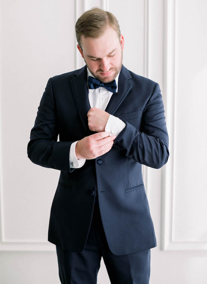 The groom putting on his cufflinks before the ceremony.