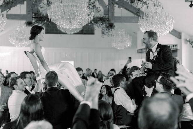 The couple lifted into the air on chairs during their reception.