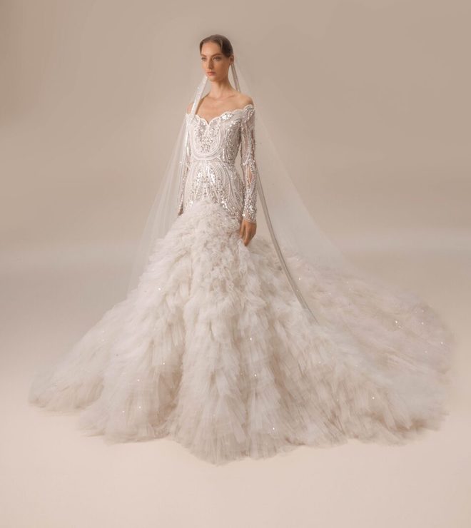 A beaded gown with long sleeves with a dramatic pleated ruffle at the bottom. 