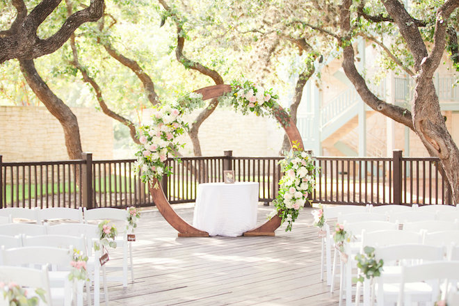 A ceremony set up with pink and white florals and luscious greenery at The Hyatt Regency Hill Country Resort and Spa