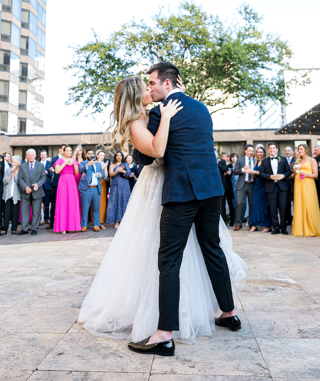 The bride and groom kissing during their alfresco celebration at The Four Seasons Hotel Houston.