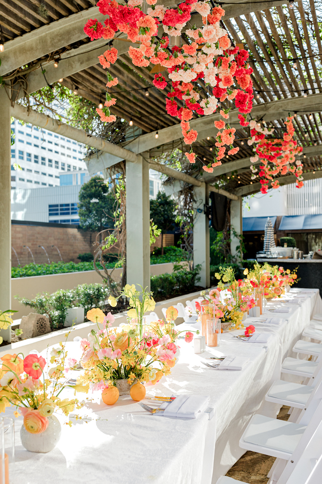 Bright florals in the center of a long reception table. 