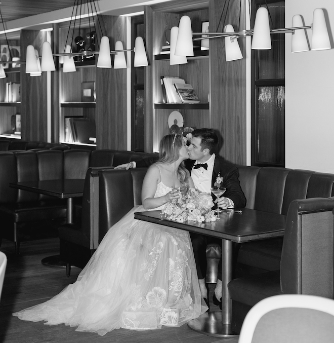 The bride and groom kissing in the lounge area of the venue.