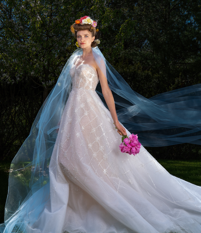 A bride wearing a gown from the Sweet Dreems collection with a blue veil.