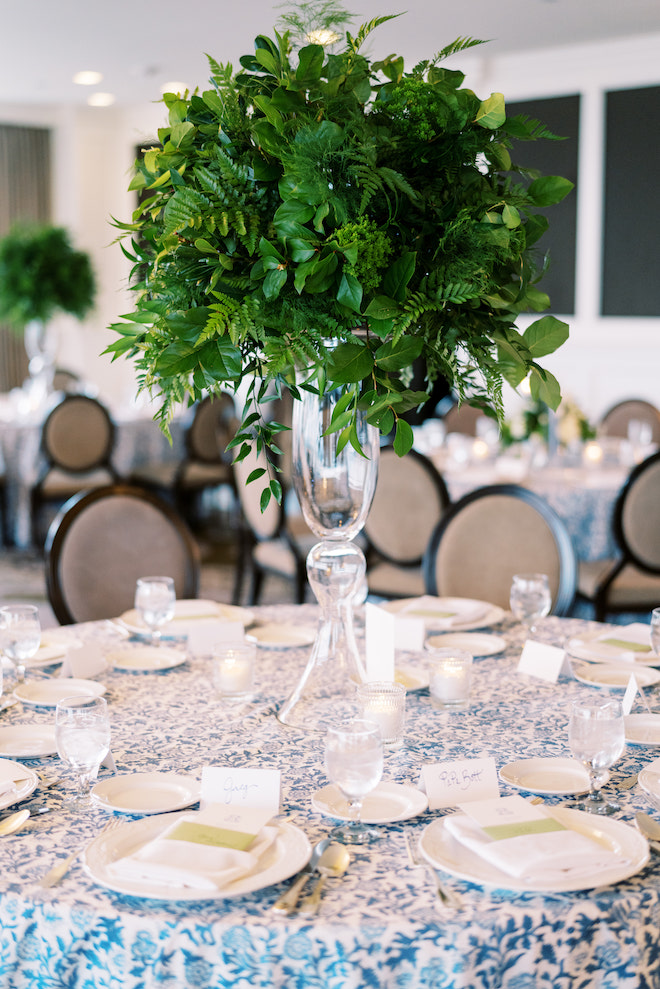 The blue and green table scape with a lush green center piece with the blue floral print linens.