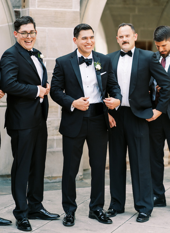 The groom smiling with his groomsmen.