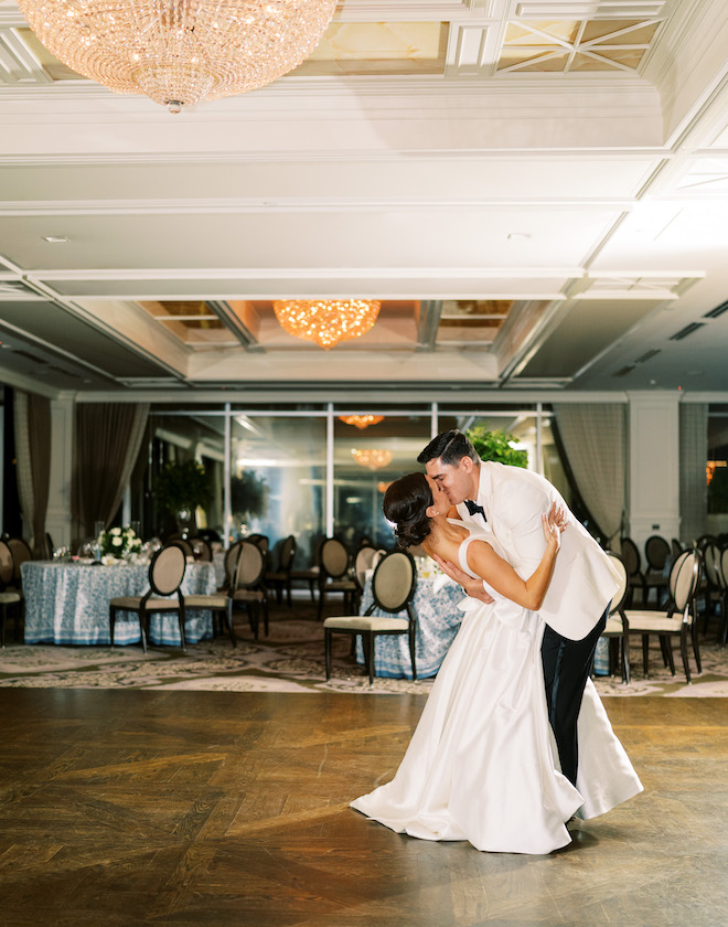 The bride and groom kissing in the Petroleum Club of Houston at their chinoiserie inspired wedding reception.
