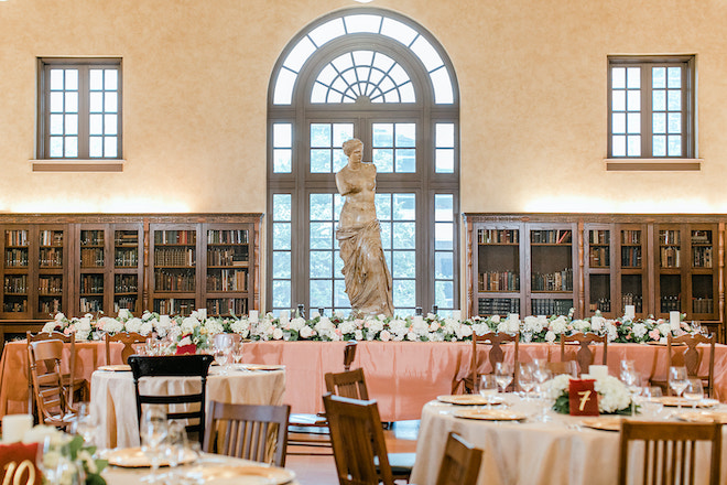 The long reception table with a statue in the back of the Julia Ideson Library.