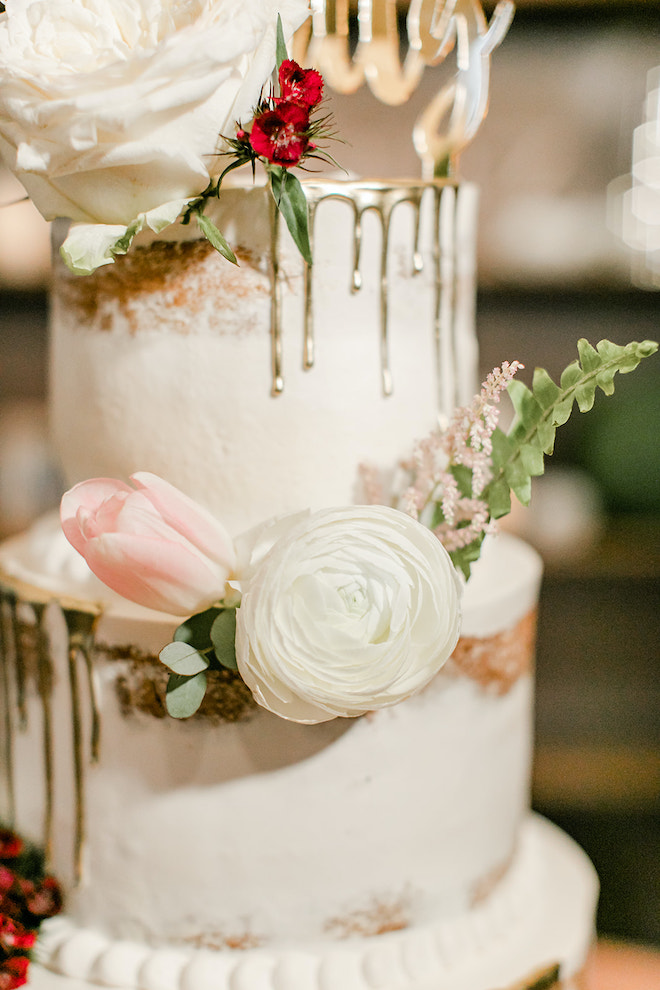 Naked cake with florals and gold icing. 