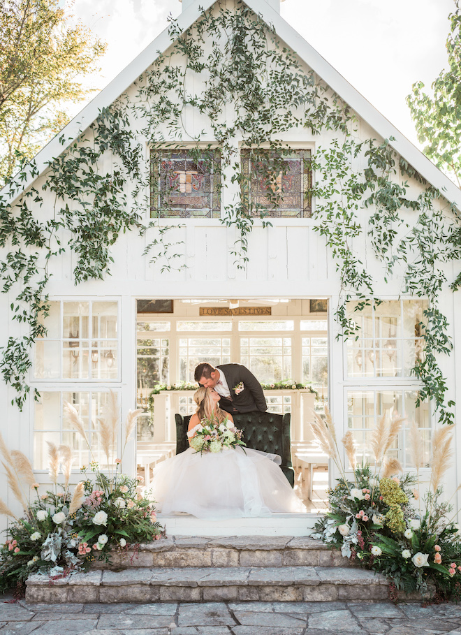 The groom kissing the brides forehead inside the chapel.