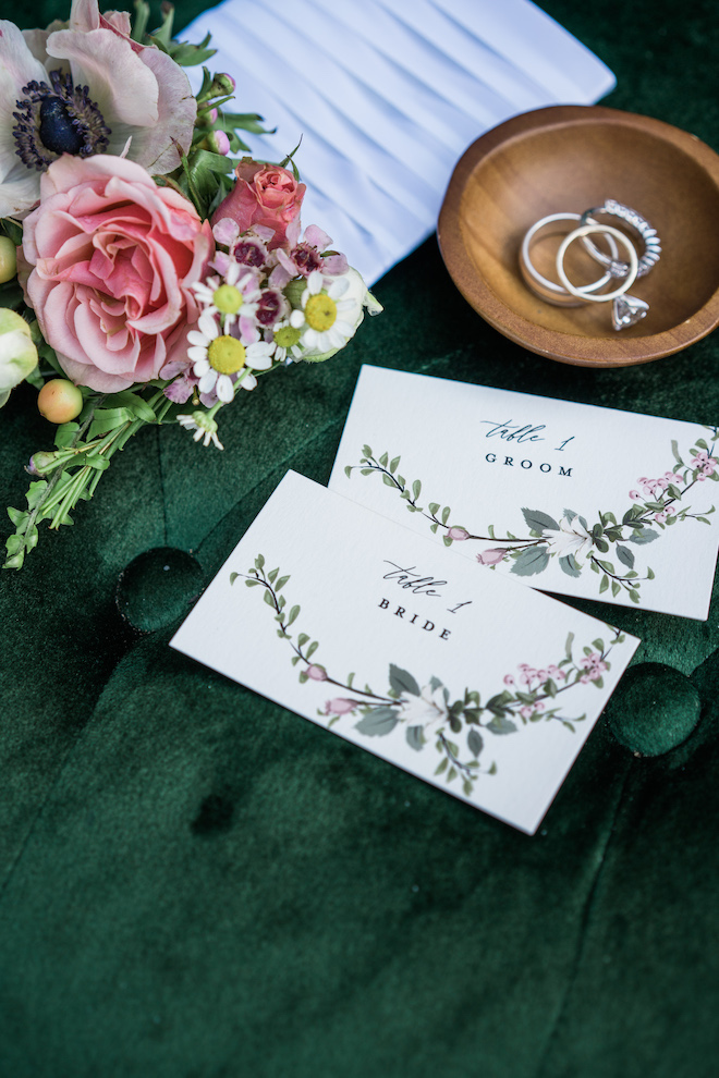 Place cards for the bride and groom on a velvet emerald green background.