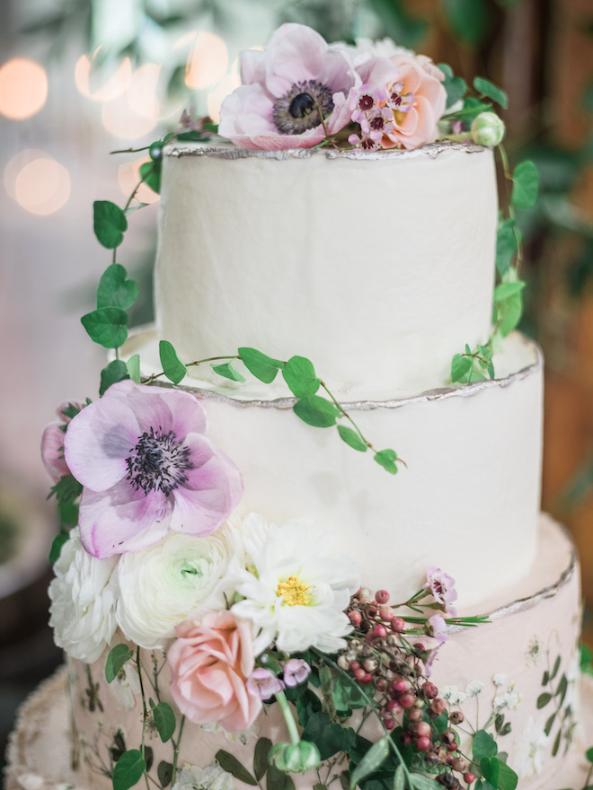 Garden-themed wedding cake garnished in flowers and greenery.