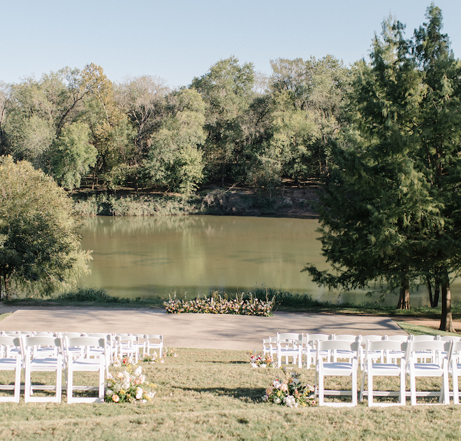 The alfresco ceremony set up before the wedding in front of the Colorado river, with white chairs and pops of florals. 