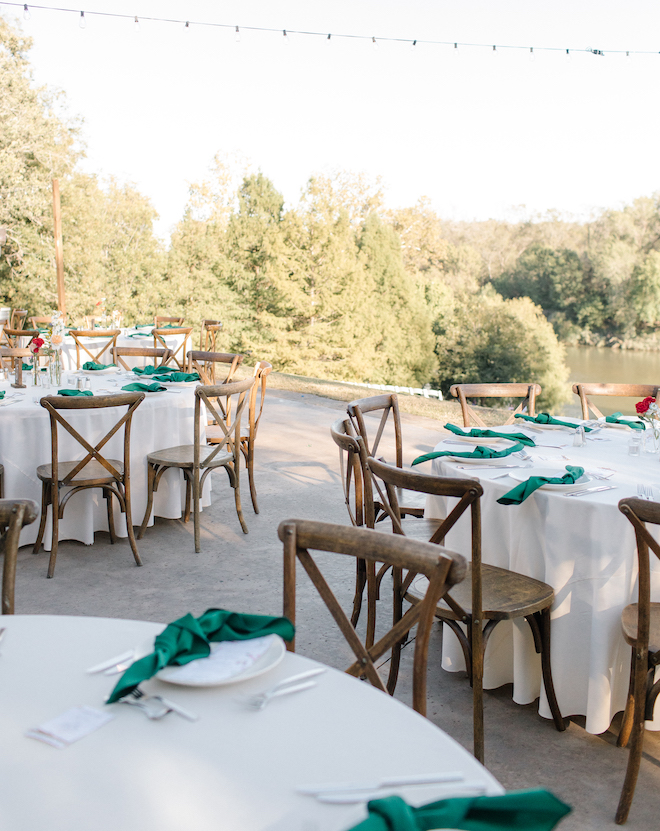 Outdoor reception tables with white table cloths and green napkins on an autumn day.