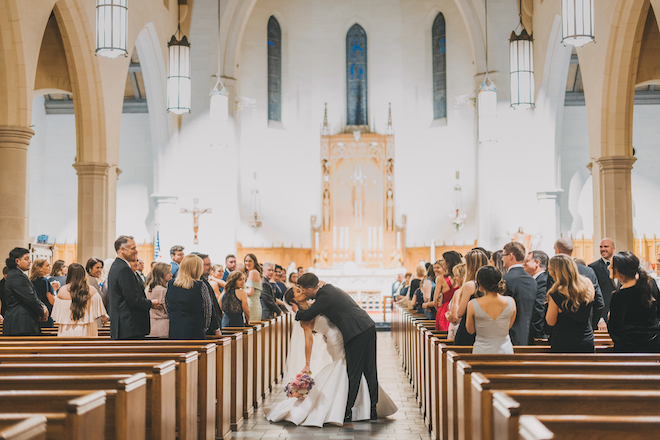 The bride and groom kissing in the church after their wedding ceremony.