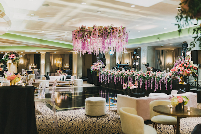 Hanging purple blooms above the dance floor at the glam ballroom reception.