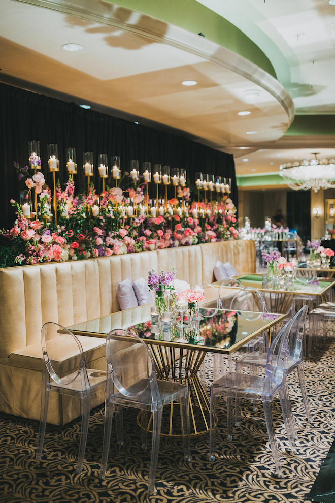 Ghost chairs and mirrored tables with delicate purple florals at the reception.