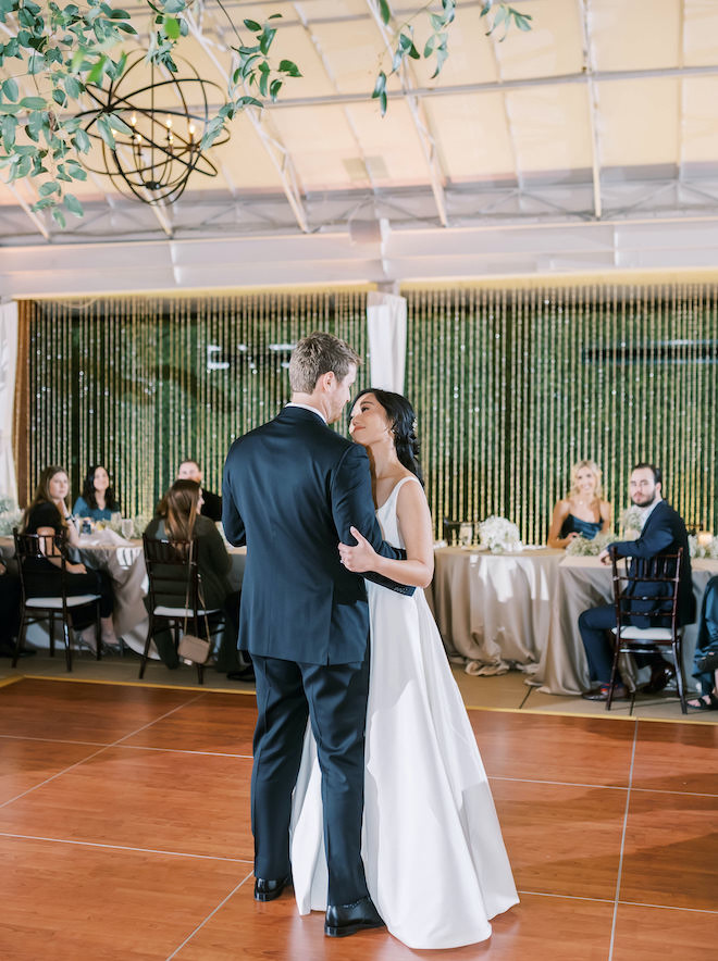 The bride and groom dancing at their romantic white and forest green wedding.