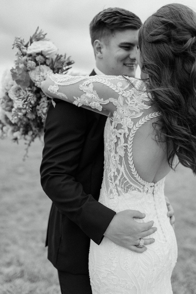 The bride and groom hugging in the field at their traditional wedding at Deep in the Heart Farms.