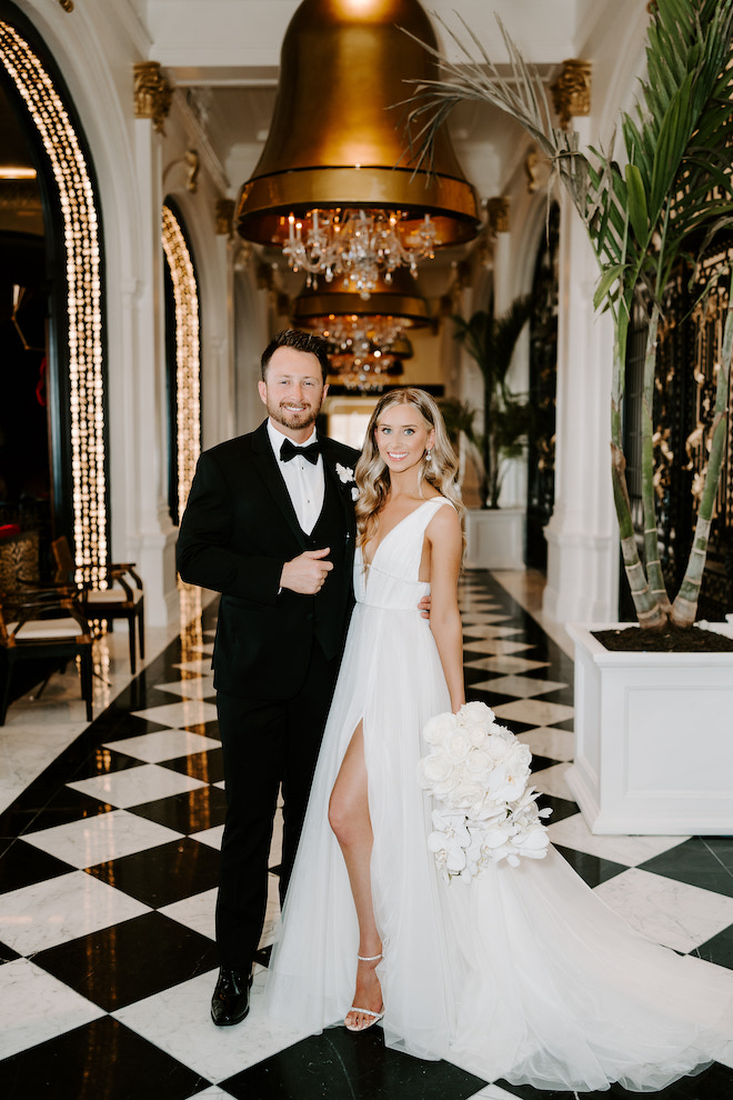 The bride and groom smiling in the hallway of the Grand Galvez for their winter wedding in Galveston, Texas.