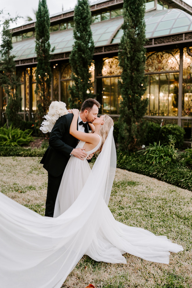 The bride and groom kissing outside the reception venue for their winter wedding in Galveston, Texas.