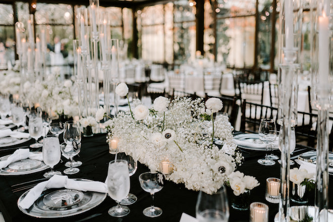 Baby's breath, candlelight and black linens decorating the reception table for a winter wedding in Galveston, Texas.