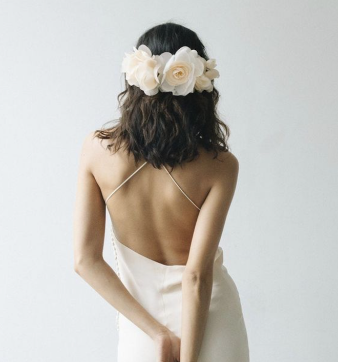 A bride with a floral headband in the back of her hair.