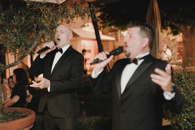 Two men singing opera at the reception.