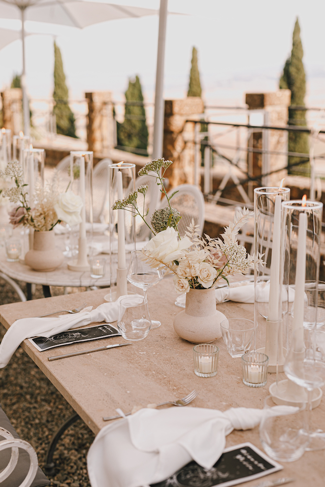 White napkins, linens and candles decorating the al fresco reception table.